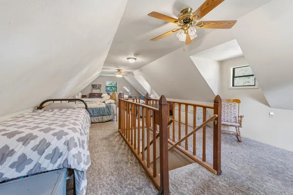 a bedroom with furniture and a chandelier fan