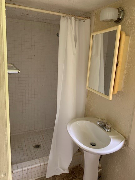 5820 1/2 Dearborn Avenue Columbus, GA 31909 - Photo 3 of 11 a bathroom with a sink a shower curtain and a mirror