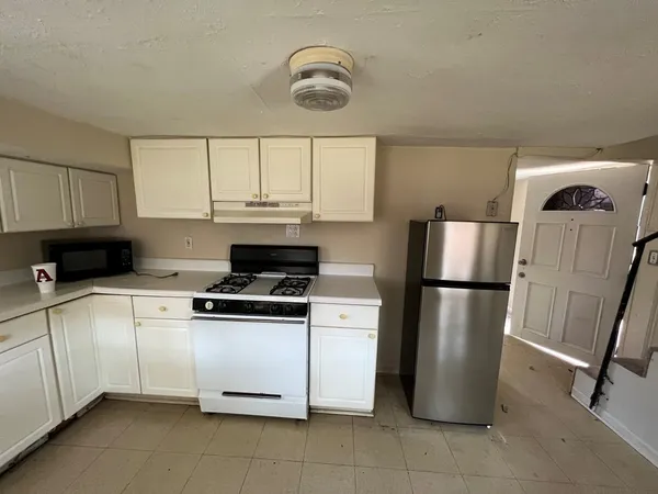 a kitchen with a refrigerator a stove a sink and a cabinets
