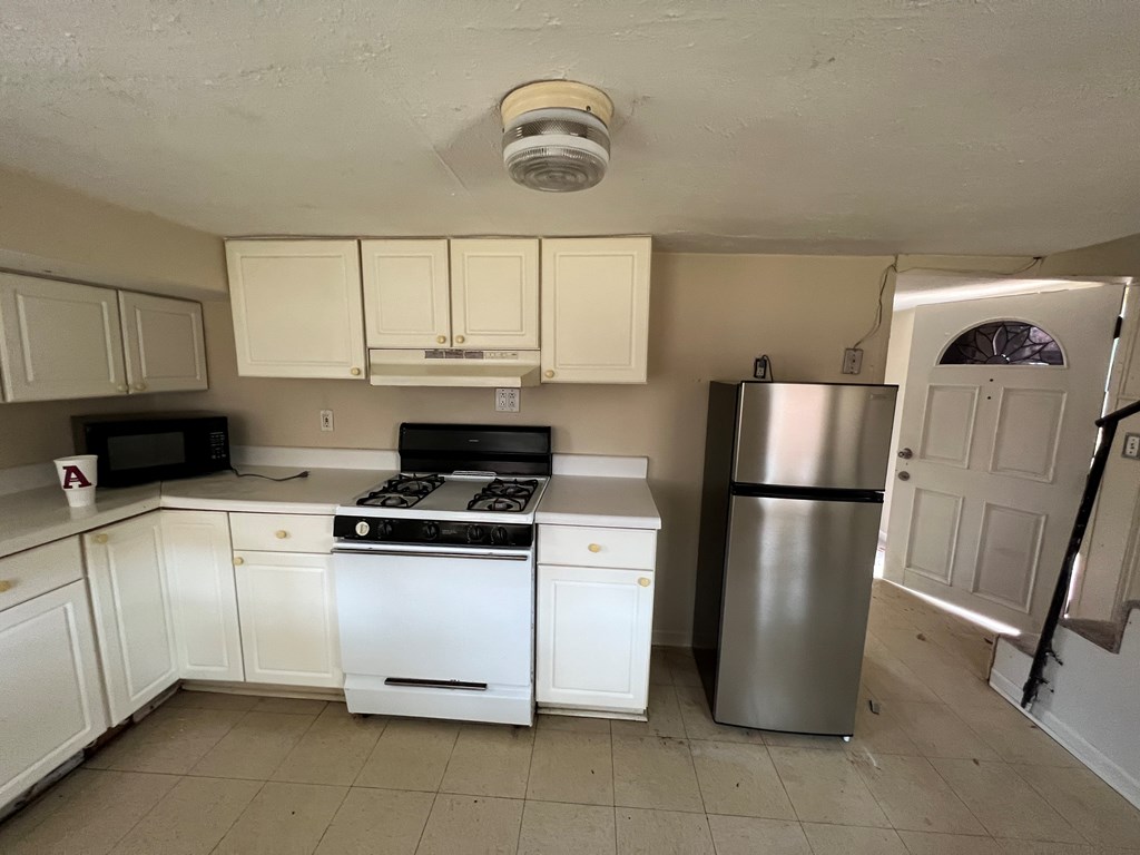 5820 1/2 Dearborn Avenue Columbus, GA 31909 - Photo 7 of 11 a kitchen with a refrigerator a stove a sink and a cabinets