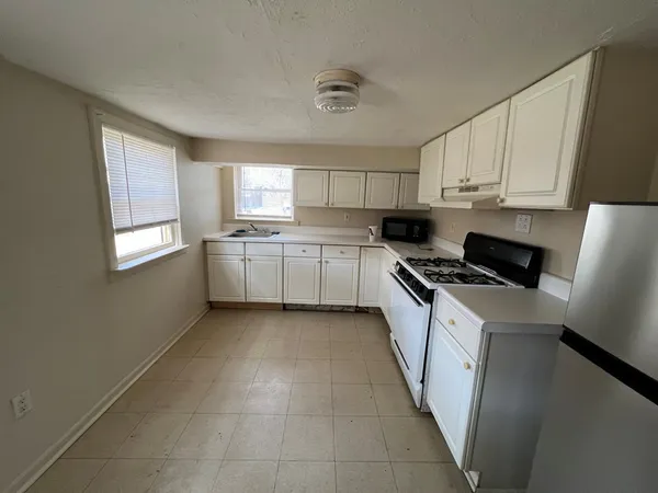 a kitchen with granite countertop cabinets stainless steel appliances a sink and a window