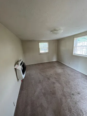 an empty room with windows and cabinet