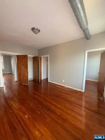a view of empty room with wooden floor