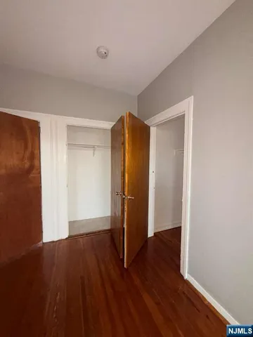 an empty room with wooden floor and closet
