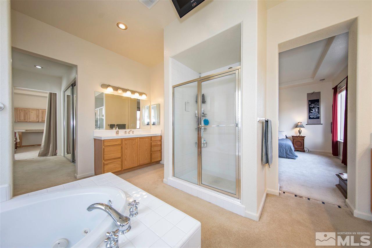 1675 Greycrest Way Reno, NV 89521 - Photo 16 of 25 a en suite bathroom with a sink a mirror and a shower