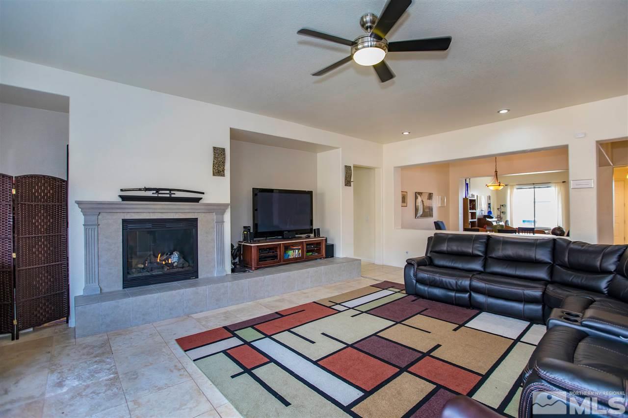 1675 Greycrest Way Reno, NV 89521 - Photo 4 of 25 a living room with furniture a flat screen tv and a fireplace