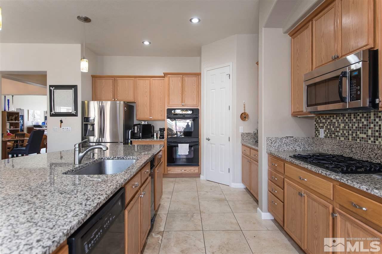 1675 Greycrest Way Reno, NV 89521 - Photo 6 of 25 a kitchen with stainless steel appliances granite countertop a sink a stove and a refrigerator