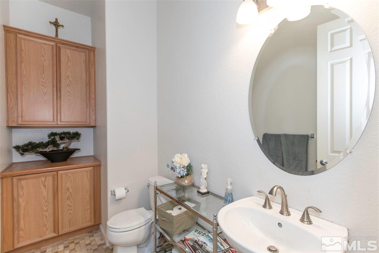 1675 Greycrest Way Reno, NV 89521 - Photo 9 of 25 a bathroom with a toilet a sink and mirror