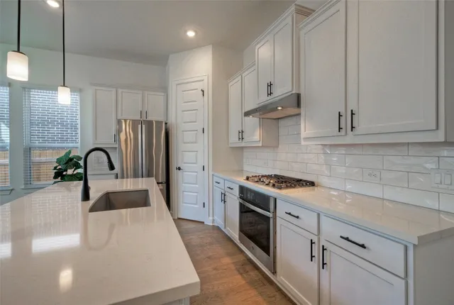 a kitchen with stainless steel appliances granite countertop a sink stove and refrigerator