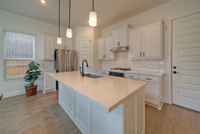a kitchen with stainless steel appliances granite countertop a sink stove and refrigerator
