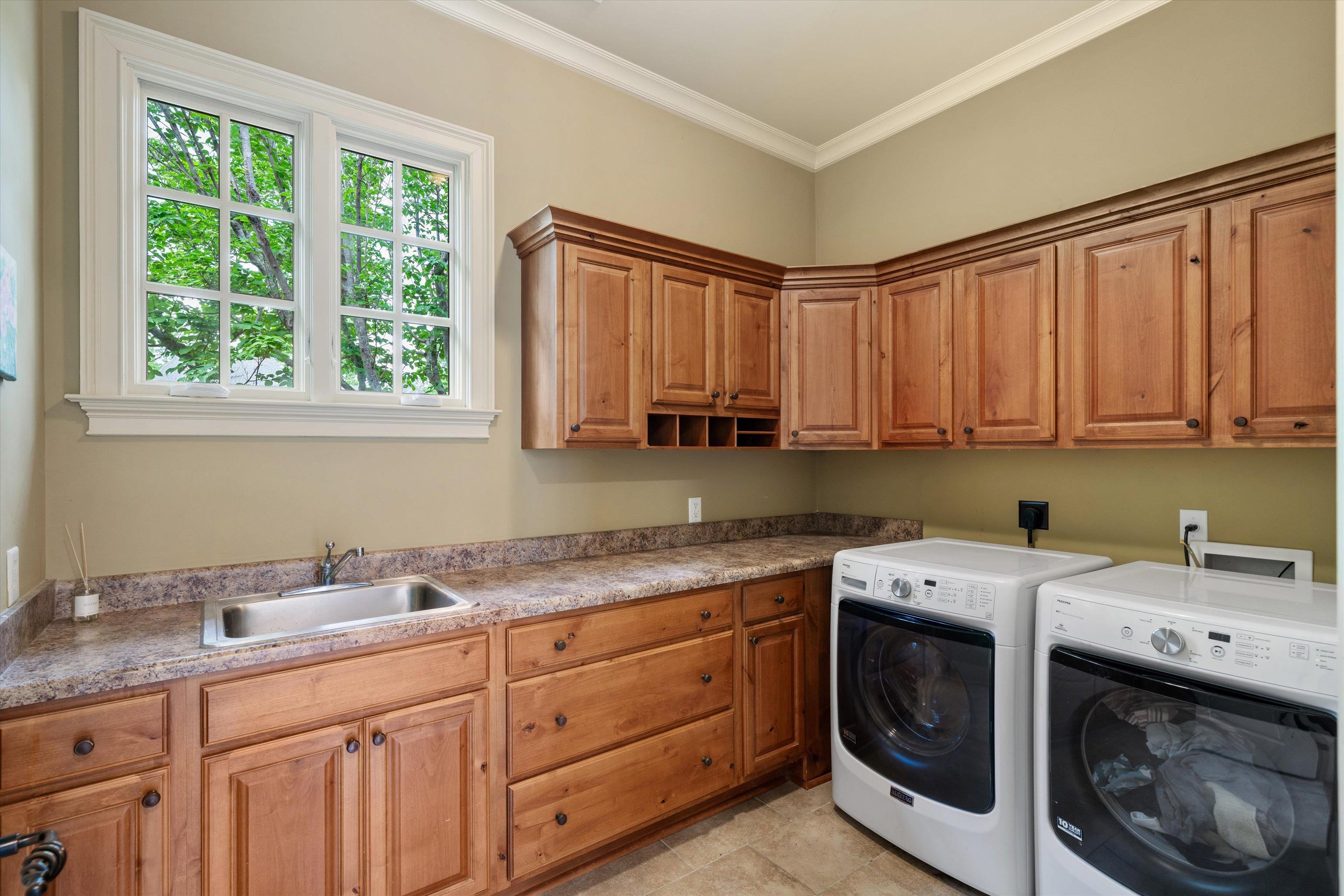 1328 Bridgepointe Drive Collierville, TN 38017 - Photo 18 of 40 Laundry area featuring washing machine and clothes dryer, cabinet space, and ornamental molding