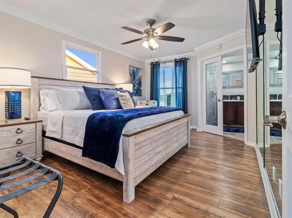 328 6th Avenue Indian Rocks Beach, FL 33785 - Photo 15 of 45 a bedroom with a large bed a chandelier and windows