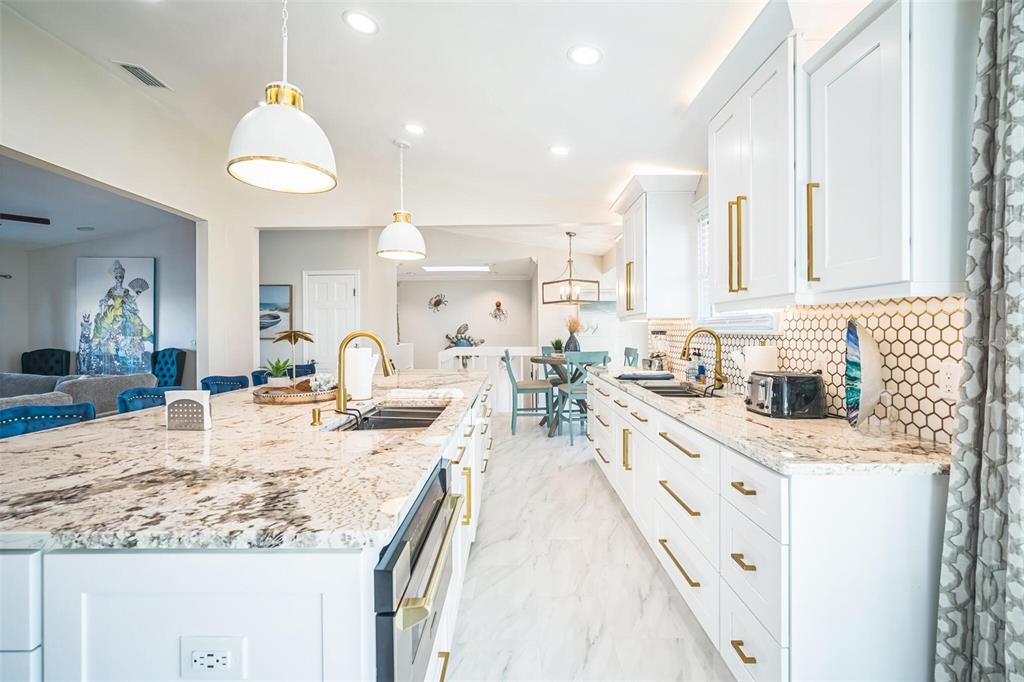 328 6th Avenue Indian Rocks Beach, FL 33785 - Photo 29 of 45 a large kitchen with granite countertop a sink a counter top space appliances and cabinets