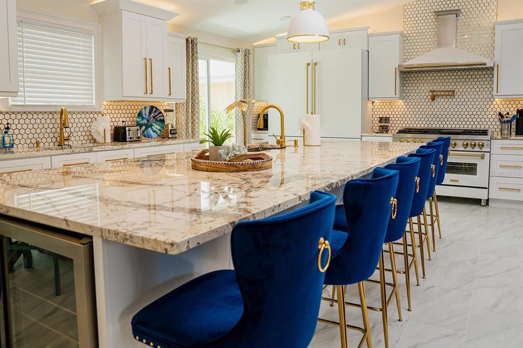328 6th Avenue Indian Rocks Beach, FL 33785 - Photo 3 of 45 a kitchen with stainless steel appliances granite countertop a sink a stove a table and chairs