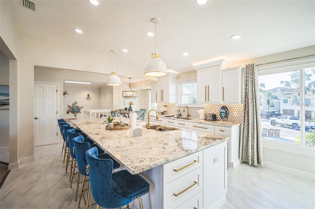328 6th Avenue Indian Rocks Beach, FL 33785 - Photo 32 of 45 an open kitchen with granite countertop kitchen island white cabinets and stainless steel appliances
