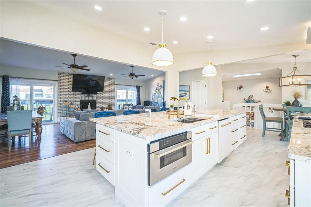 328 6th Avenue Indian Rocks Beach, FL 33785 - Photo 37 of 45 a large white kitchen with a stove top oven and chandelier
