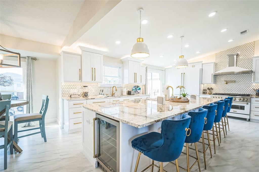 328 6th Avenue Indian Rocks Beach, FL 33785 - Photo 40 of 45 a kitchen with stainless steel appliances kitchen island granite countertop a table chairs sink and cabinets