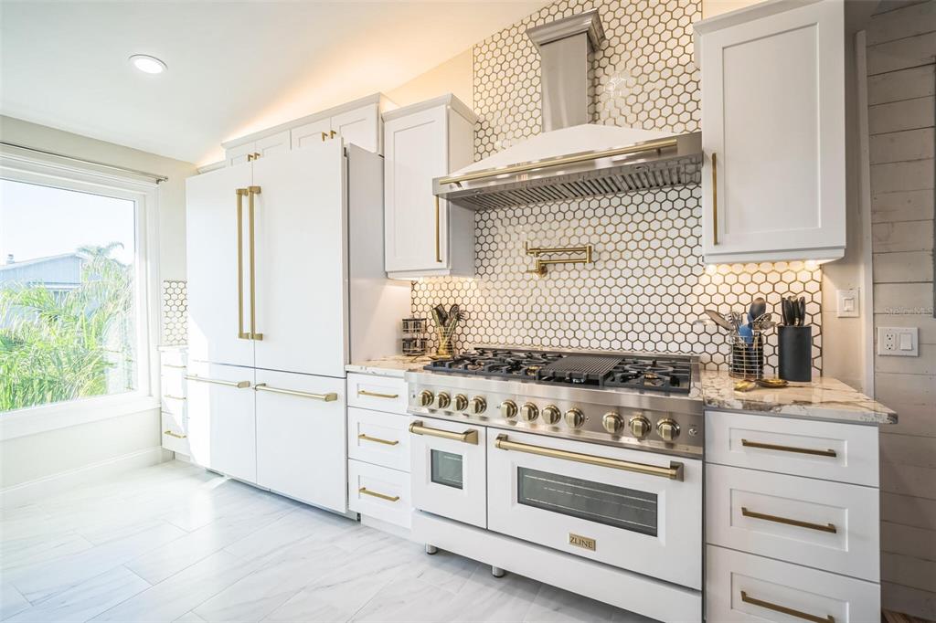 328 6th Avenue Indian Rocks Beach, FL 33785 - Photo 4 of 45 a kitchen with white cabinets and white appliances