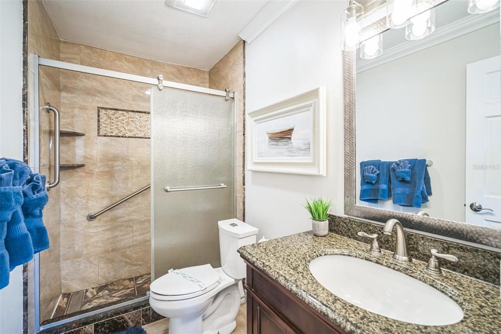 328 6th Avenue Indian Rocks Beach, FL 33785 - Photo 43 of 45 a bathroom with a granite countertop sink toilet a mirror and shower