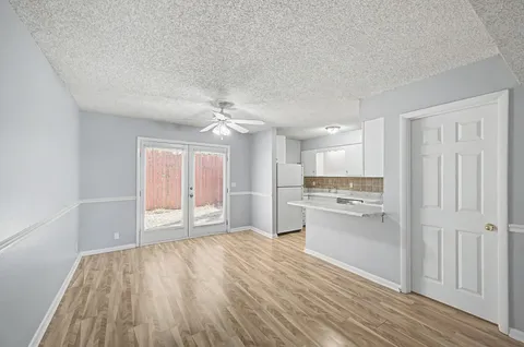 a view of a kitchen with a sink and dishwasher a refrigerator with wooden floor