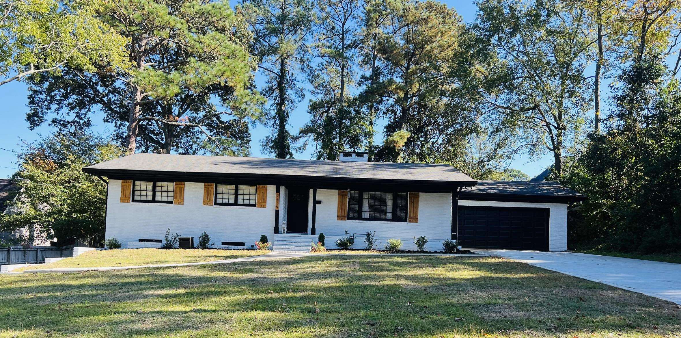 2419 Raeford Road Fayetteville, NC 28305 - Photo 1 of 36 a front view of a house with a garden and trees