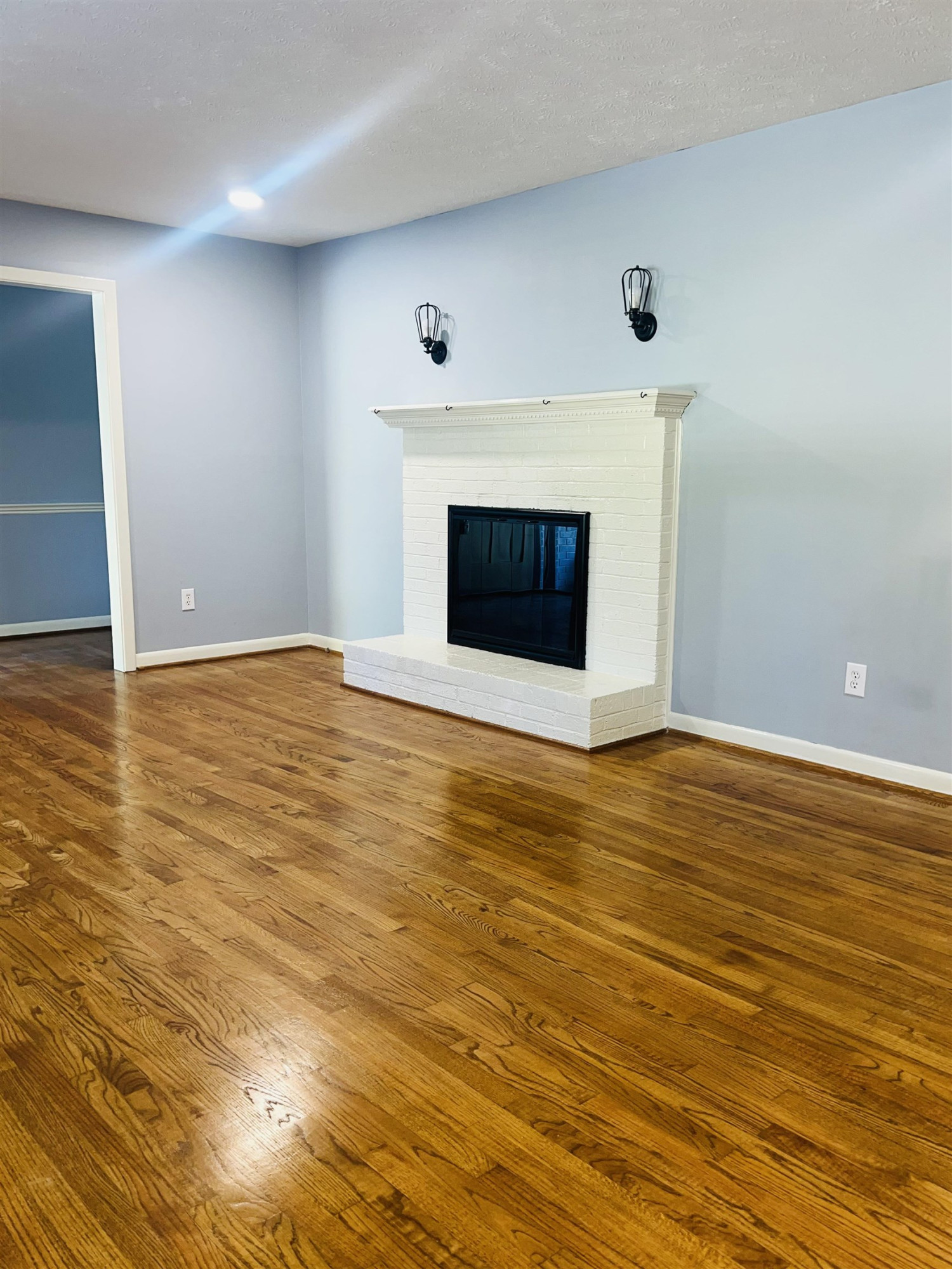 2419 Raeford Road Fayetteville, NC 28305 - Photo 4 of 36 an empty room with wooden floor and fireplace