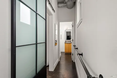 a view of a hallway with wooden floor and staircase