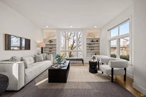 a living room with furniture and floor to ceiling windows