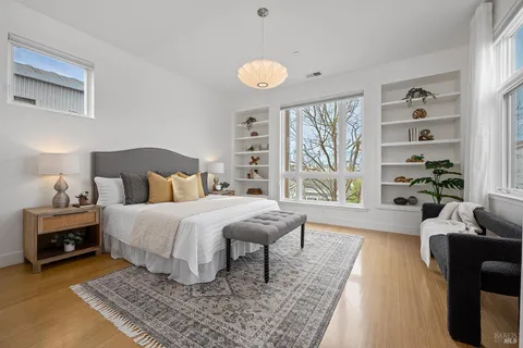 a bedroom with a bed a dresser and next to a window