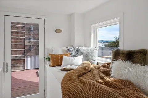 a view of a balcony with chairs and wooden floor