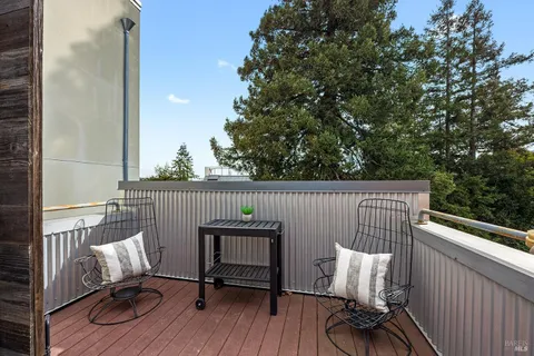 a balcony with wooden floor table and chairs