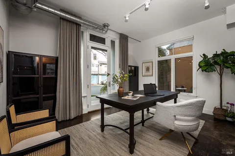 a view of a workspace with furniture and window