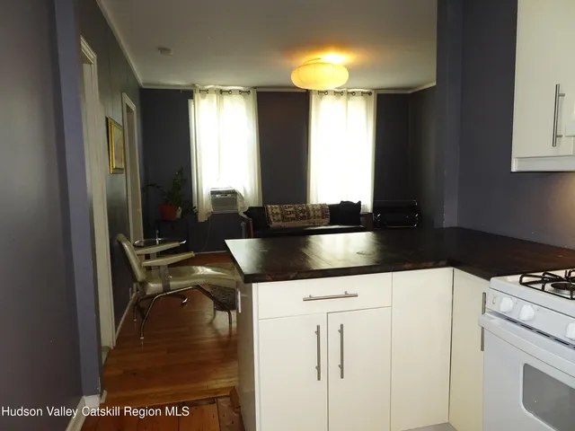 a kitchen with granite countertop a sink a stove and cabinets