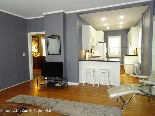 a view of a kitchen with kitchen island and a view of living room
