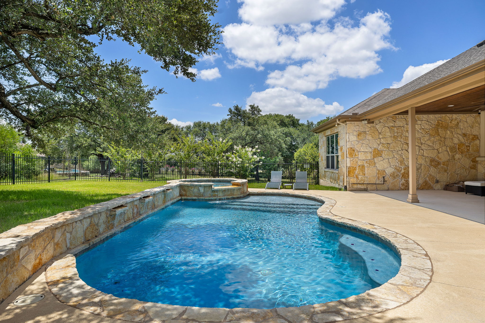 231 Marbella Way Georgetown, TX 78633 - Photo 30 of 40 An inviting in-ground pool with a stone-clad spa awaits in this private, fenced backyard.