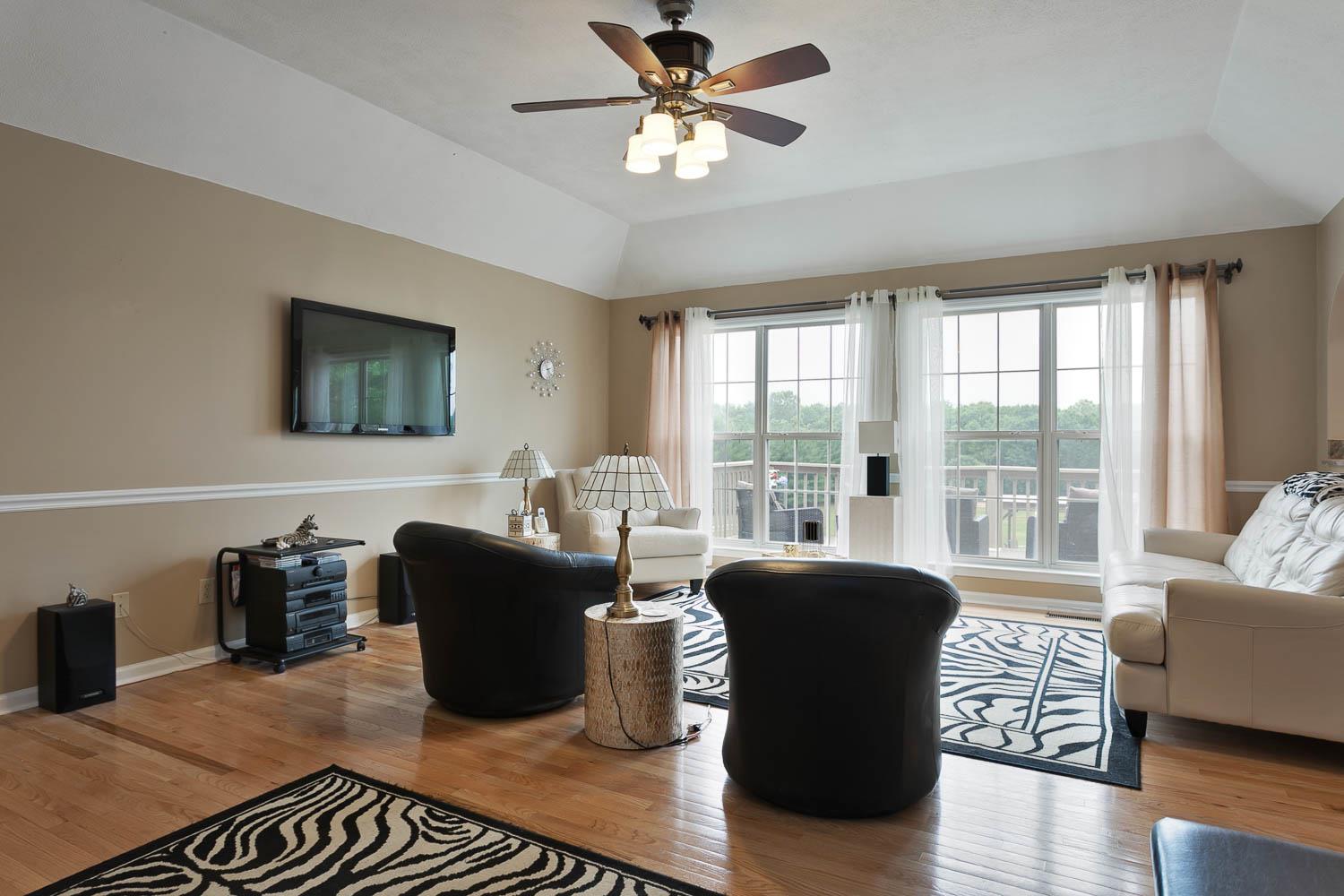 1018 Rip Steele Road Columbia, TN 38401 - Photo 7 of 28 a living room with couches a coffee table and a flat screen tv with wooden floor