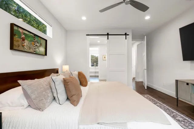 a kitchen with a stove a sink and white cabinets with wooden floor