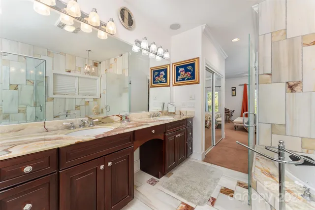 a spacious bathroom with a granite countertop sink a mirror and a shower
