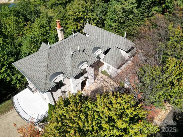 an aerial view of a house with a yard and trees