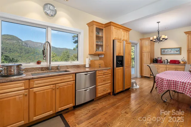 a open kitchen with stainless steel appliances granite countertop a stove a refrigerator a sink and dishwasher with wooden floor