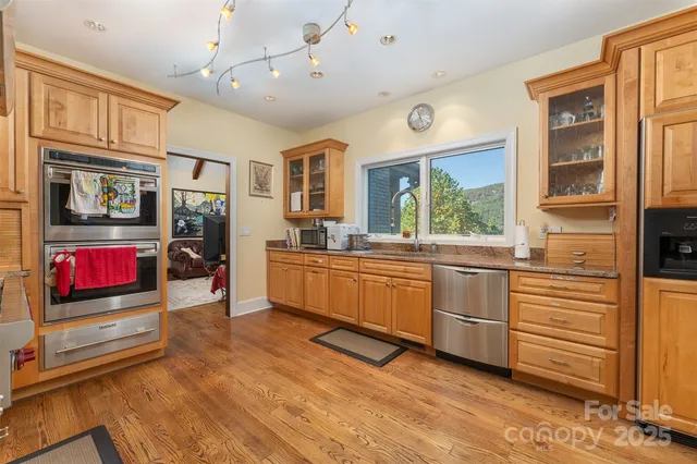 a kitchen with stainless steel appliances kitchen island granite countertop a stove and a sink