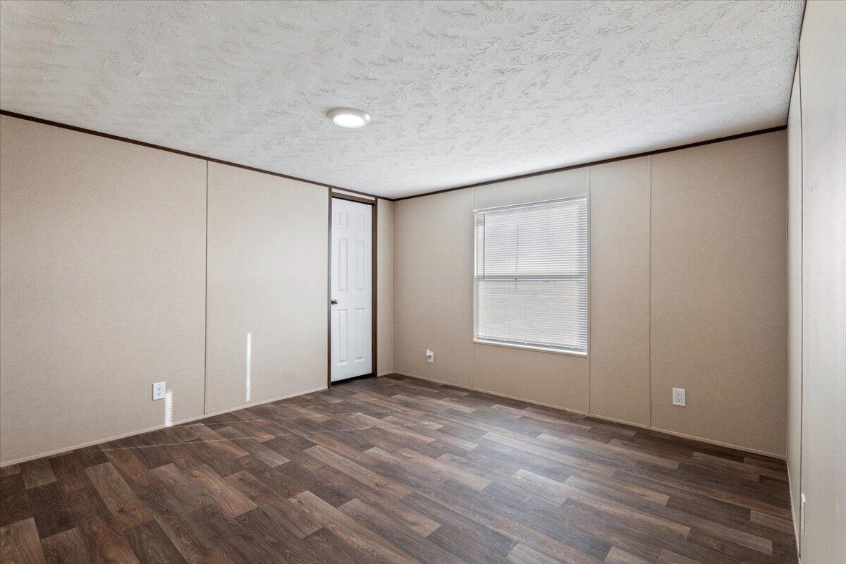 508 Sage Road Tahoka, TX 79373 - Photo 20 of 26 a view of an empty room with a window and hardwood floor