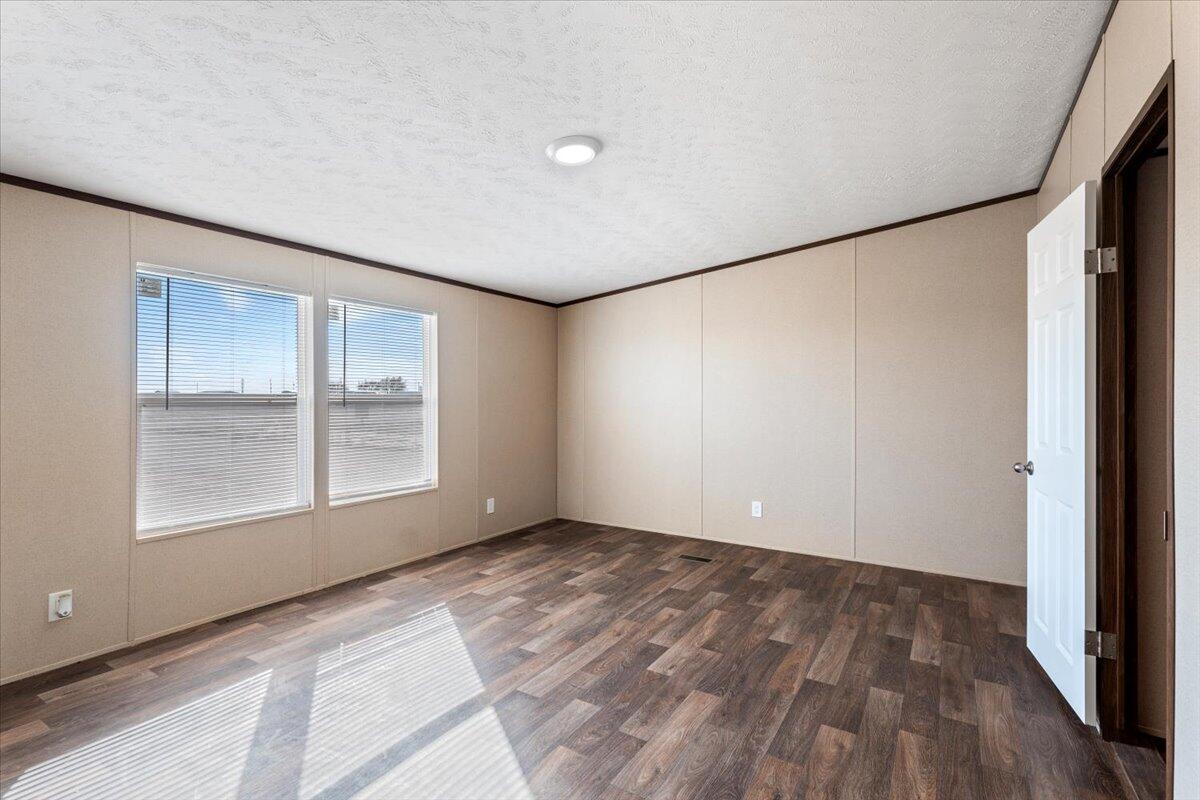 508 Sage Road Tahoka, TX 79373 - Photo 10 of 26 an empty room with wooden floor and windows