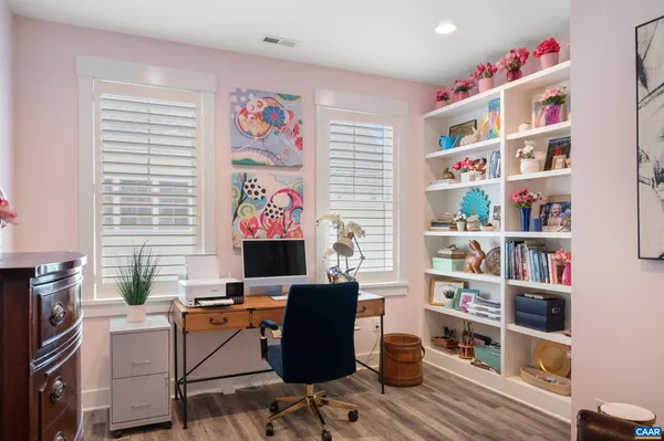 a work room with furniture a bookshelf and a window