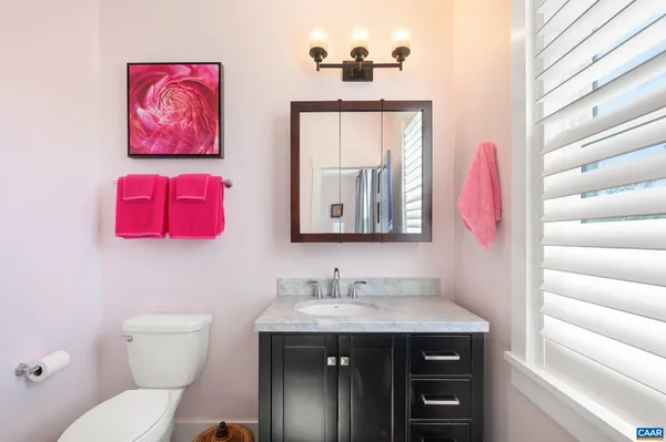 a bathroom with a toilet a sink and a mirror