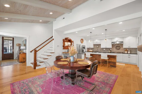 a dining room with furniture a rug and a floor to ceiling window