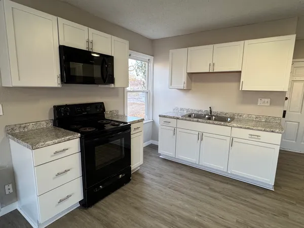 a kitchen with a sink stove and cabinets