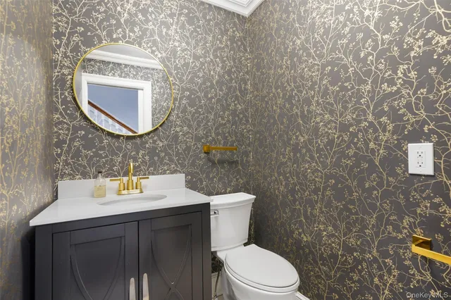 a bathroom with a sink mirror vanity and toilet