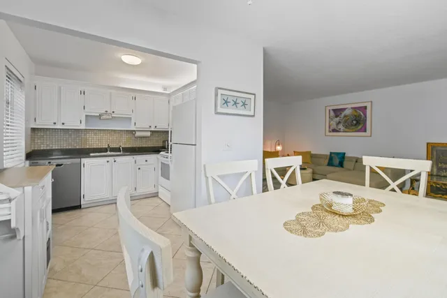 a kitchen with stainless steel appliances kitchen island granite countertop a sink a stove a table and chairs