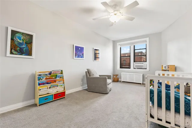 a living room with baby crib furniture and a window